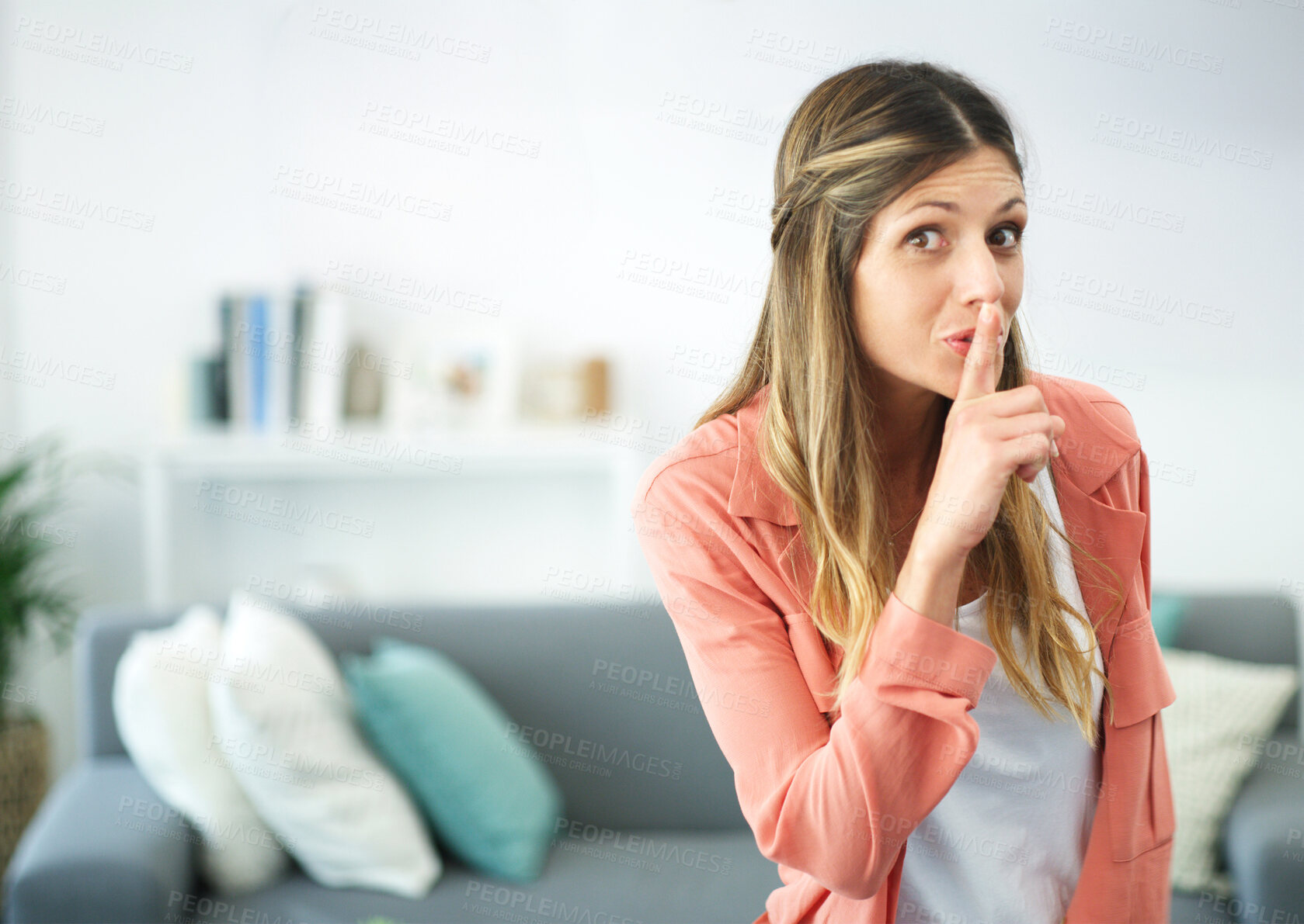 Buy stock photo cropped shot of a woman posing with her finger on her lips