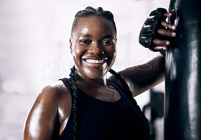 Buy stock photo Black woman, portrait and boxing bag for fitness, sweat and confidence for workout. Training, combat sports and cardio for body health and wellness, smile and gloves for African person in gym