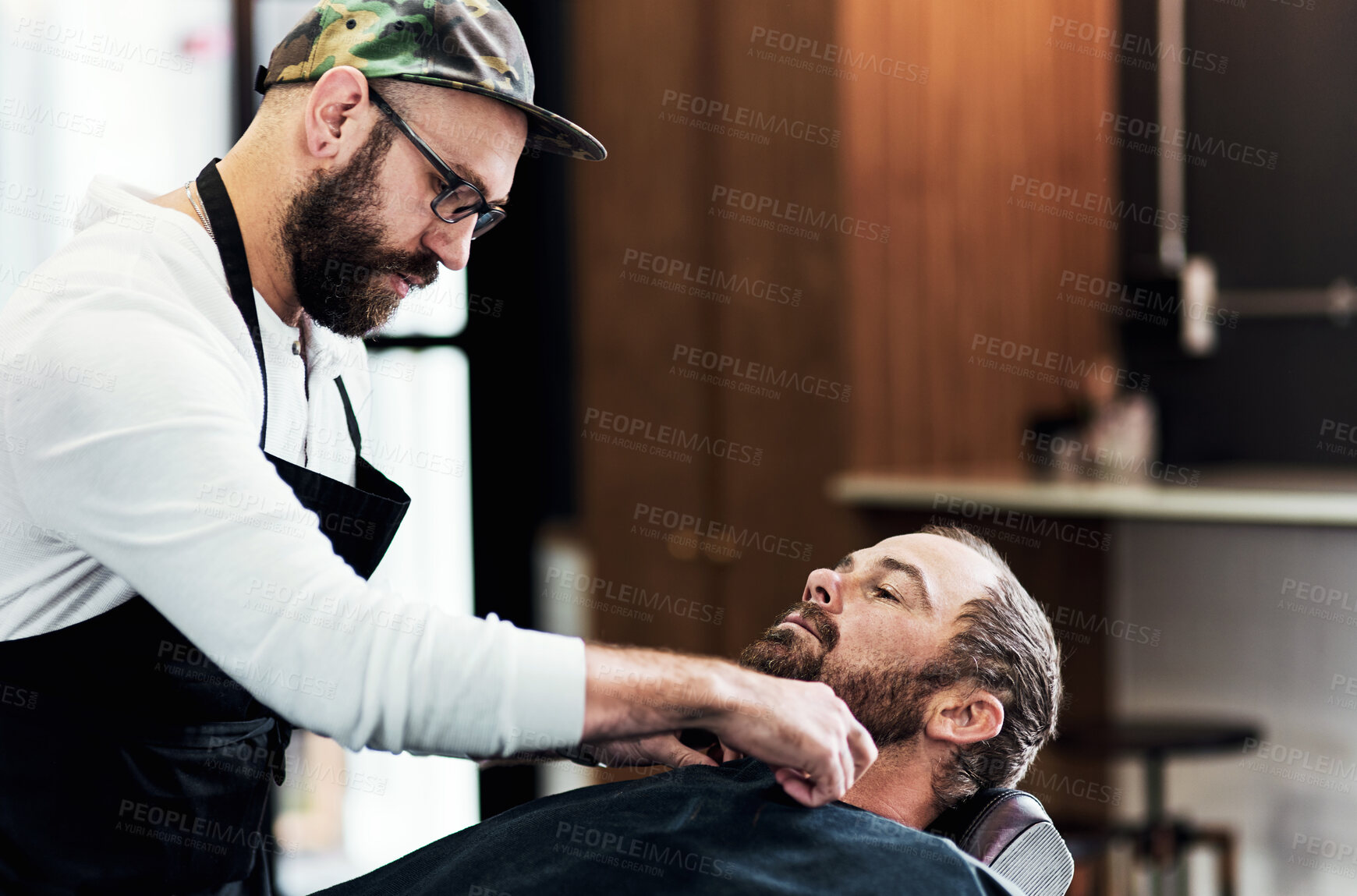 Buy stock photo Barber, salon and man with customer for shave, haircut and grooming for hygiene, wellness and beauty. Barbershop, haircare and person with shaving equipment for beard service, parlor and hairdresser