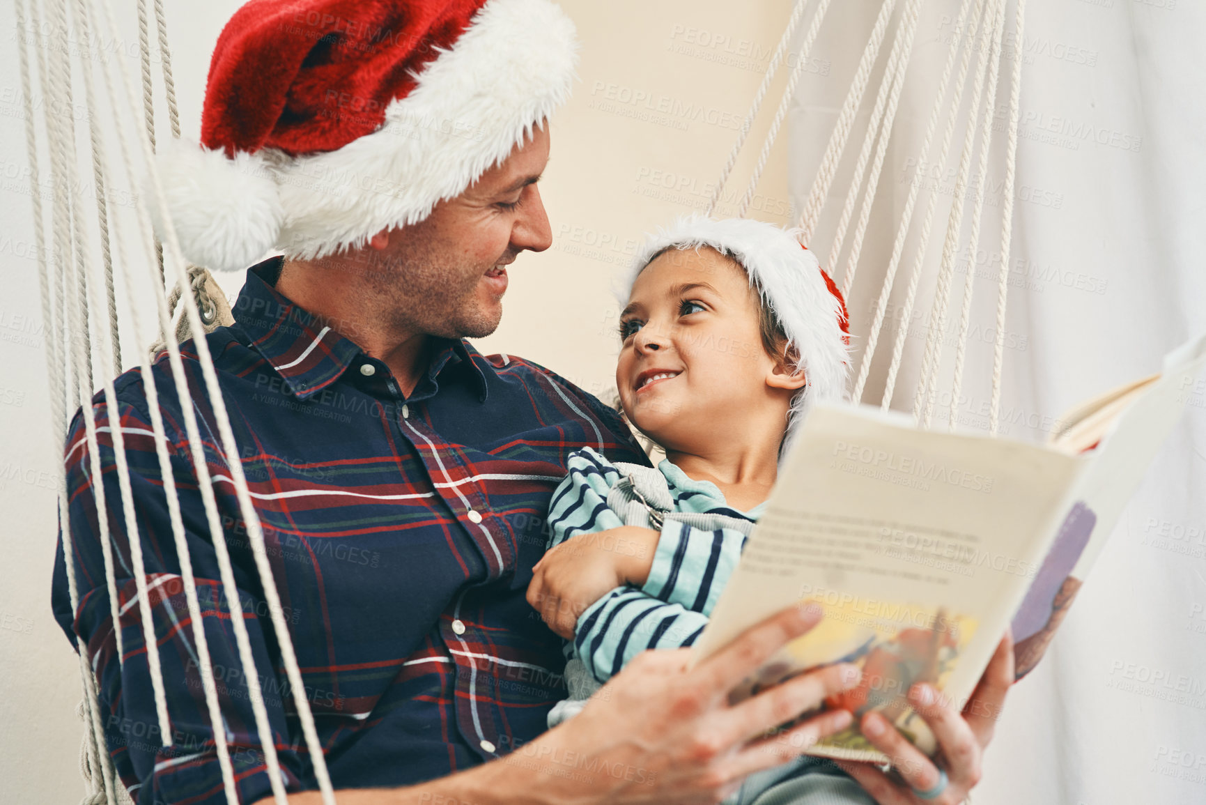 Buy stock photo Dad, son and reading with book on christmas day at home for story, novel or december. Father bonding with young child, kid or little boy for fairytale, chapter or childhood on festive weekend