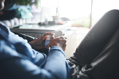 Buy stock photo Cropped shot of an unrecognisable woman playing video games on the sofa at home