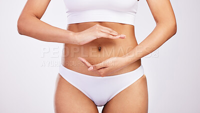 Buy stock photo Stomach, digestion and hands of woman to frame abdomen for gut health or wellness in studio background. Healthy, person and planning to lose weight with diet, nutrition or gesture for celiac or IBS