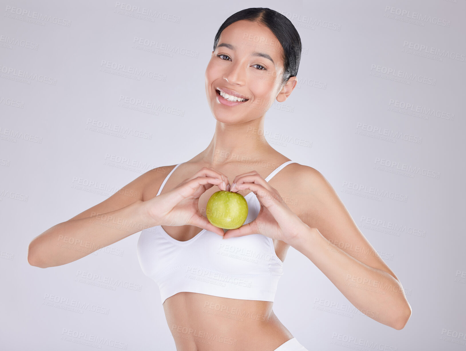 Buy stock photo Apple, smile and portrait of woman, studio and nutrition for health with food, underwear and wellness. White background, fruit and face of person, heart and happiness with hands, diet and snack