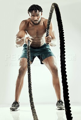 Buy stock photo Black man, studio and battle rope for exercise or fitness, athlete and white background for body or strength. Strong, muscle training and challenge with male person, biceps power and equipment