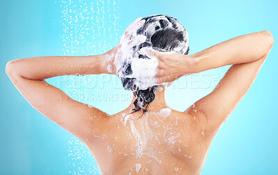 Buy stock photo Woman, washing or showering in blue studio background for cosmetics, hygiene and wellness. Female person, naked and wet with water drops cleaning body for grooming, skin care and treatment or bath