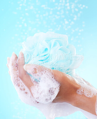 Buy stock photo Shower, sponge and hands with foam, water and blue background with product for cleaning and hygiene. Studio, loofah and soap for exfoliation, morning and bath puff for wash of person and eco friendly