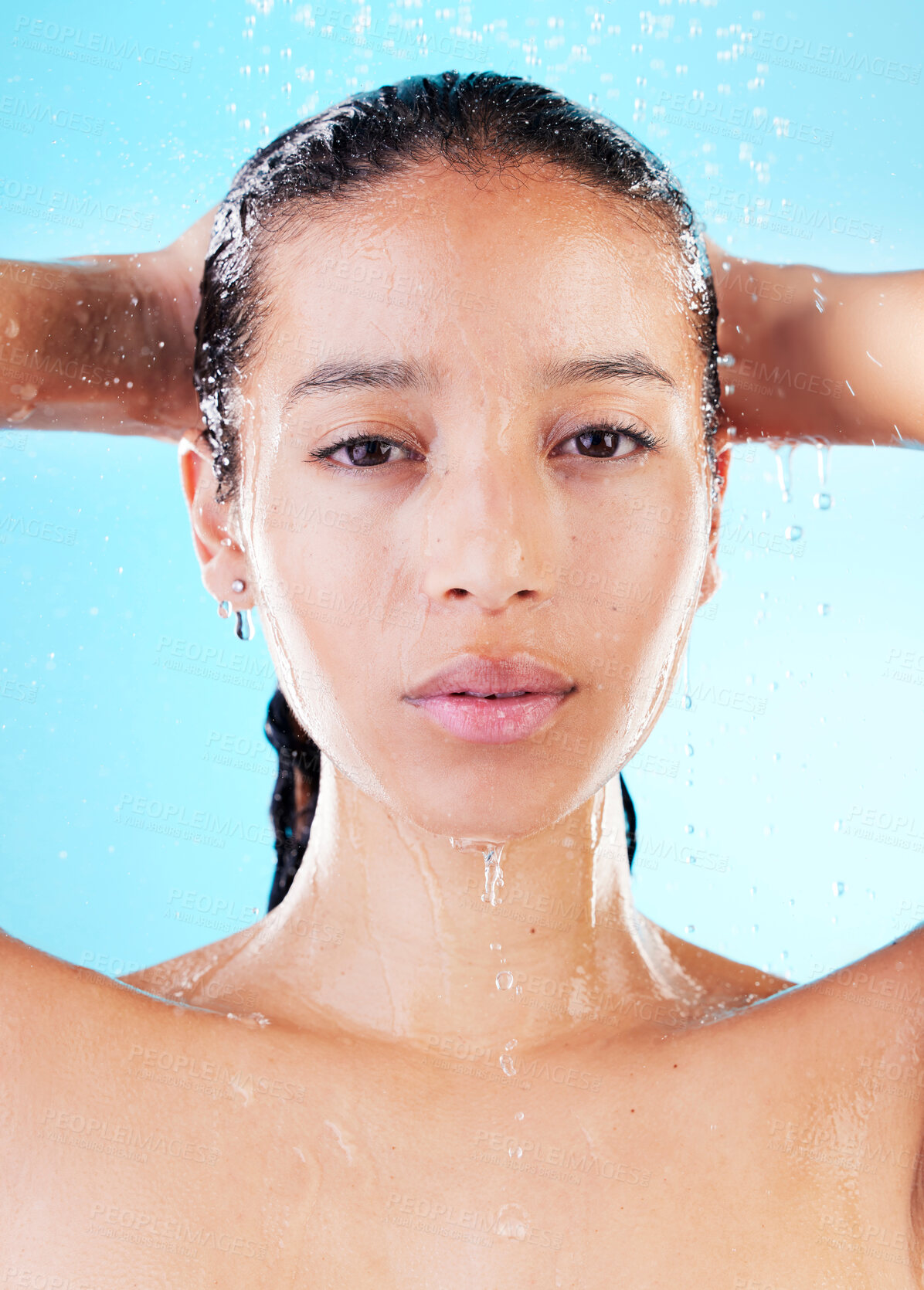 Buy stock photo Portrait, shower and woman with water splash, drops and grooming routine on blue studio background. Person, hygiene and girl with liquid, skincare and washing with dermatology, wellness and aesthetic