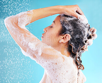 Buy stock photo Cleaning, hair care and woman washing in studio for hygiene, shampoo or skincare on blue background. Back, wellness and model body with water splash for morning routine, shower foam or dermatology