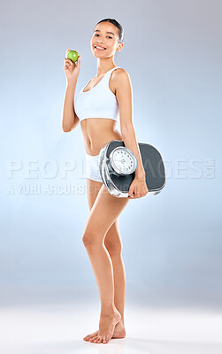 Buy stock photo Happy woman, portrait and apple with scale for weight loss, diet or healthy nutrition on a blue studio background. Female person or nutritionist with natural organic fruit for balance or wellness