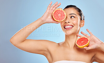 Buy stock photo Woman, grapefruit and skincare with vitamin c for natural glow, beauty and nutrition benefits for vegan diet in studio. Female person, dermatology and citrus food for skin detox by blue background