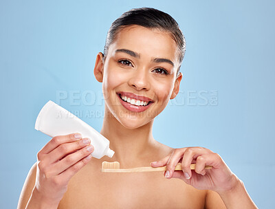 Buy stock photo Woman, studio and portrait with toothbrush or toothpaste, dental care and mouth wellness for hygiene. Bamboo, smile and eco friendly product on blue background, fresh breath and oral health or beauty