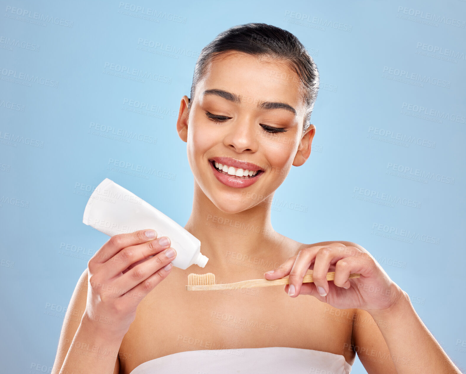 Buy stock photo Woman, studio and happy with toothbrush or toothpaste, dental care and mouth wellness for hygiene. Bamboo, smile and eco friendly product on blue background, fresh breath and oral health or beauty