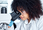 One mixed race scientist with curly hair wearing safety goggles and gloves analysing medical test samples on a microscope in a lab. Young woman doing forensic research and experiment to develop a cure