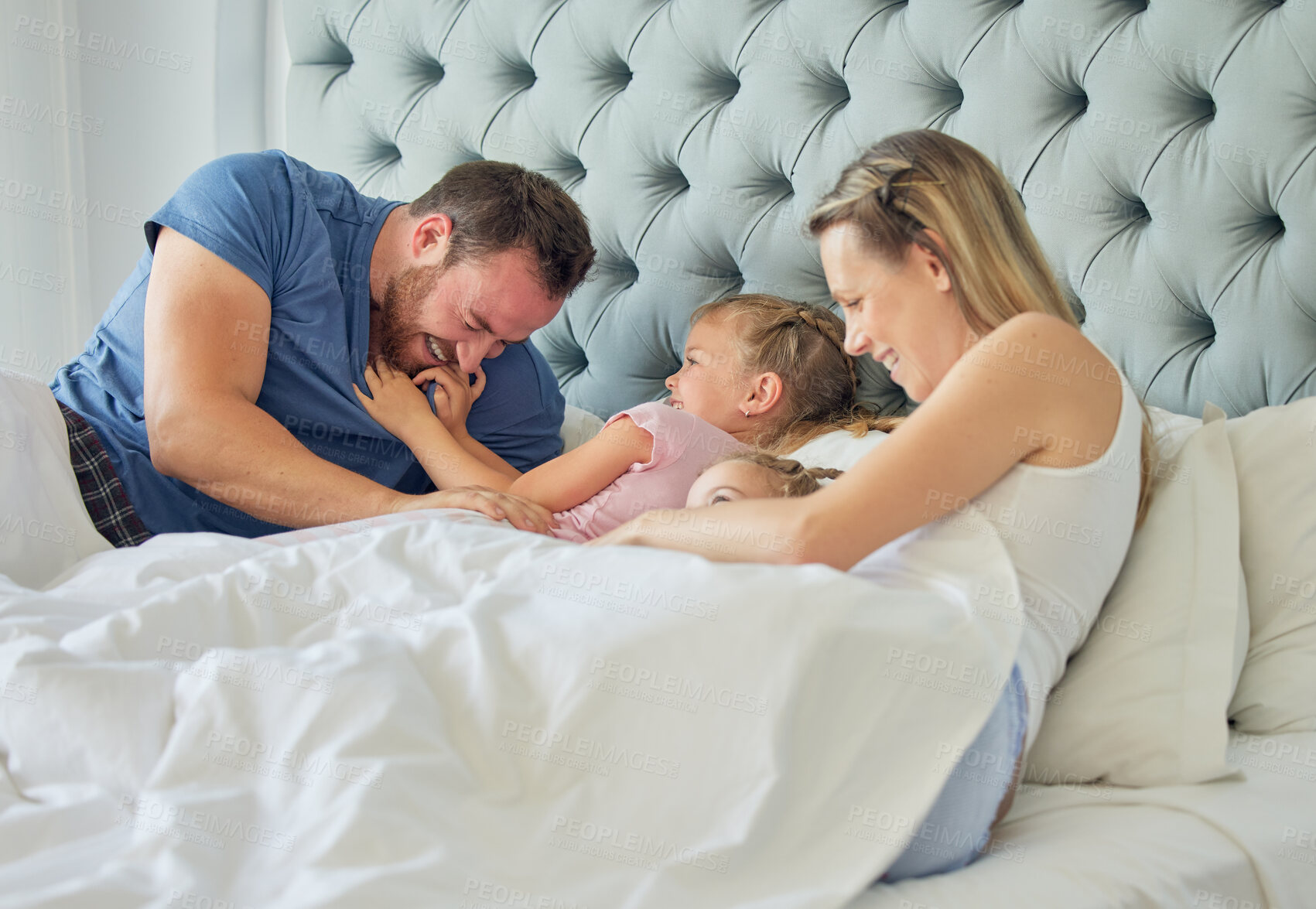 Buy stock photo Parents, kids and laughing in bedroom on morning, talking and play together in home. Family, children and weekend for lying on bed or bonding for relationship, support and peace in security or tickle