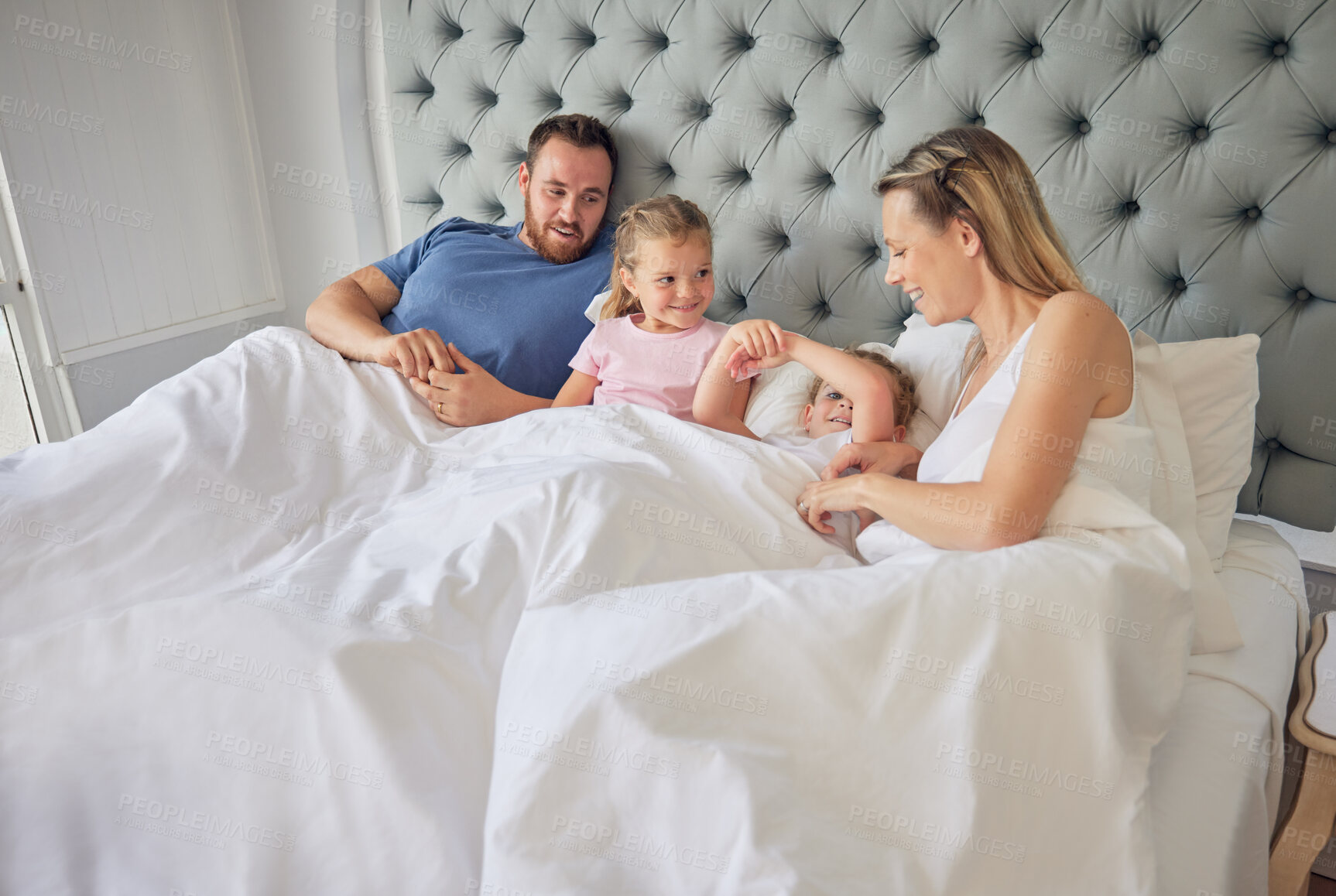 Buy stock photo Parents, kids and wake up in bedroom on morning, talking and relax together in home. Family, children and weekend for lying on bed or bonding for relationship, support and peace in security or unity