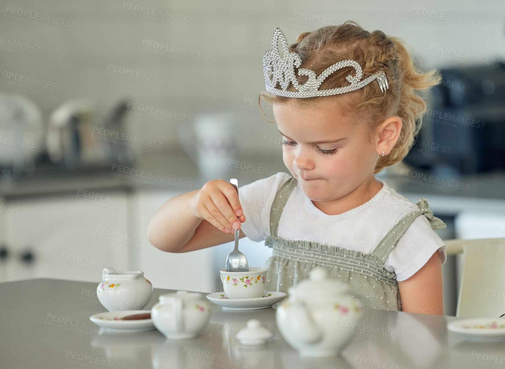 Buy stock photo Girl, child and playing in kitchen with tea party for childhood fun, cookies and tiara for pretend imagination. Kid, stir cup and toys in home with spoon for youth, game and growth or development.