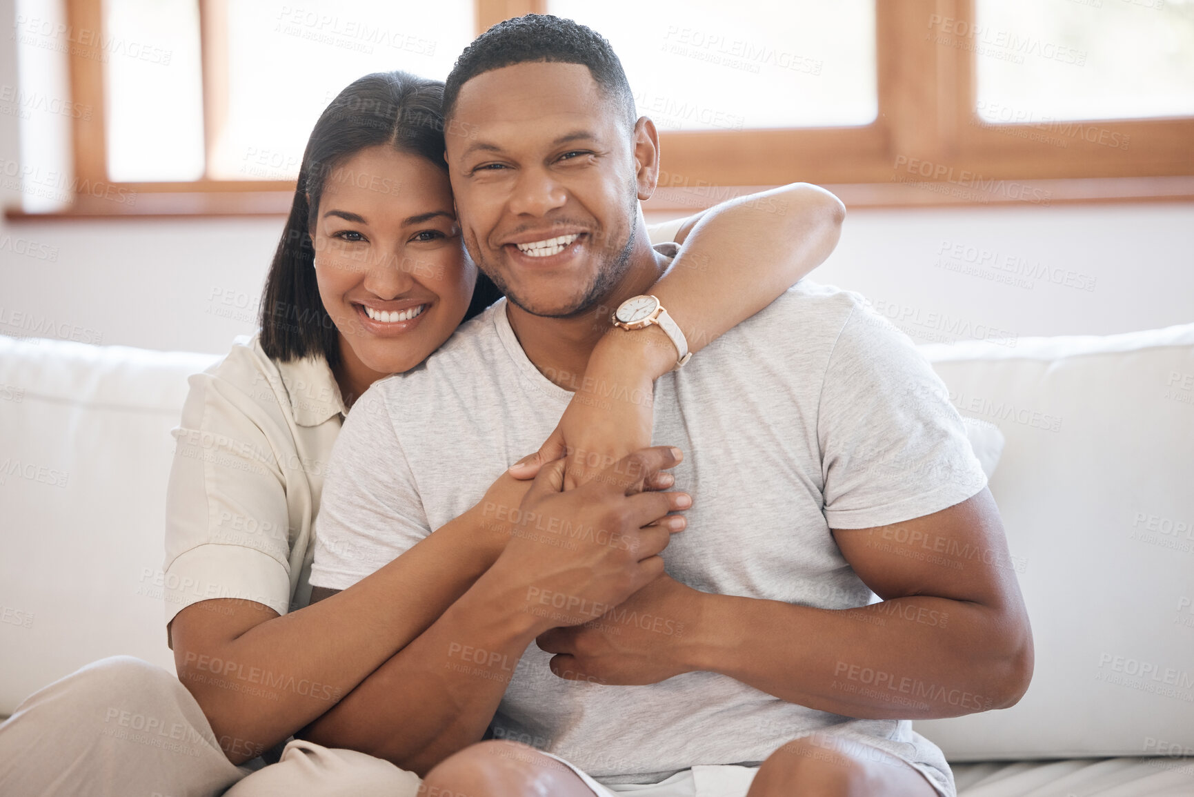 Buy stock photo Smile, portrait and couple hug on a sofa with love, trust and bonding in their home together. Happy, face and people embrace while holding hands in living room with support, care or romance in house