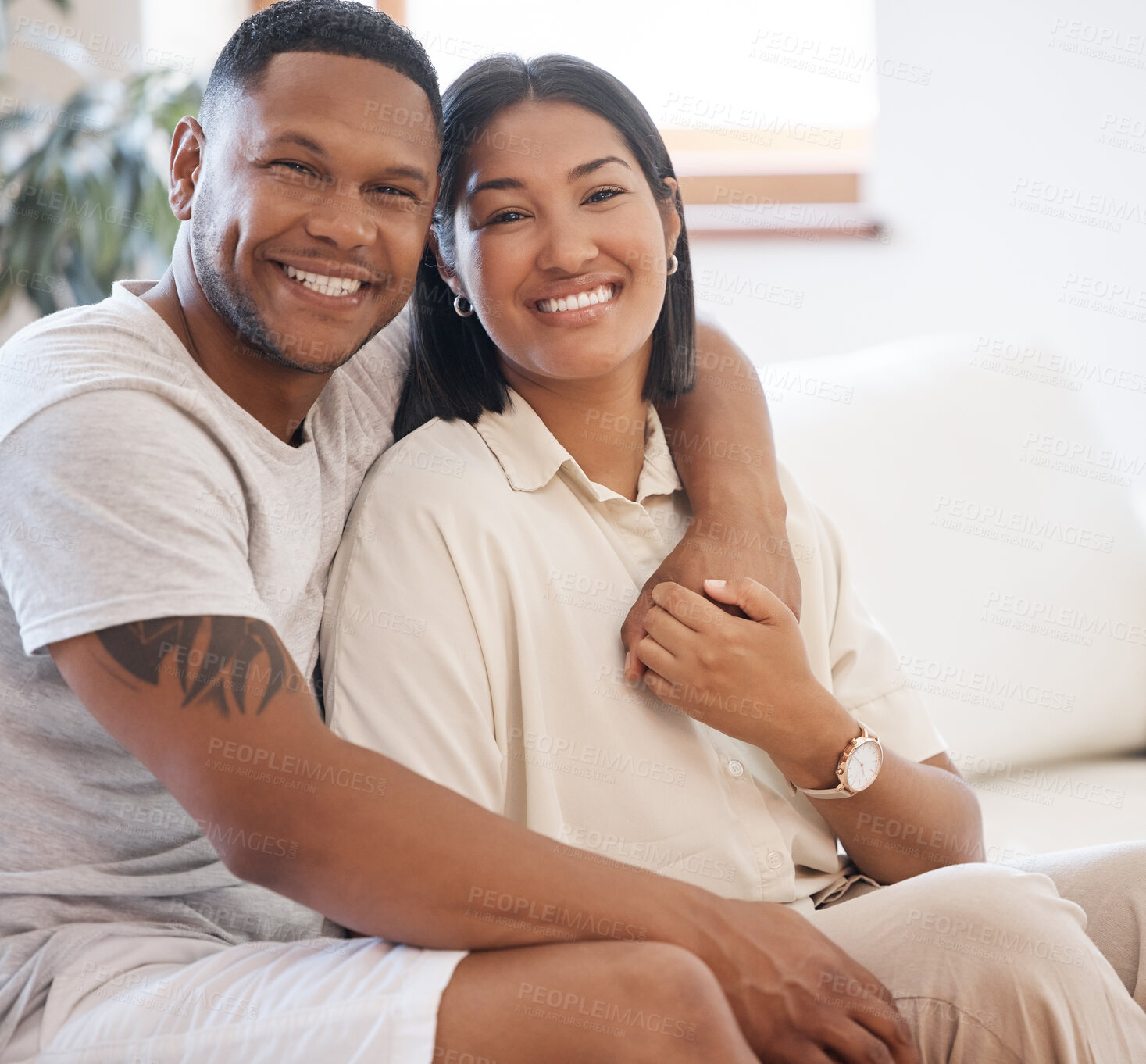 Buy stock photo Happy, portrait and couple hug on a sofa with love, trust and bonding in their home together. Face, smile and people embrace while holding hands in living room with support, care or romance in house