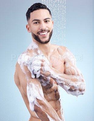 Buy stock photo Shower, soap and portrait of man with skincare, grooming and fresh morning bathroom routine on blue background. Health, wellness and male person in water for cleaning, washing and hygiene in studio.