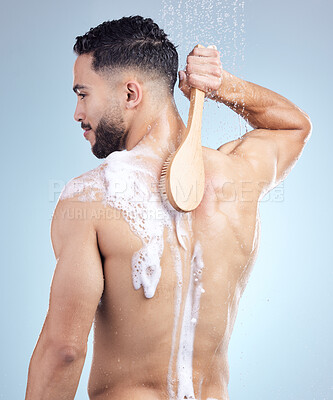 Buy stock photo Shower, soap and man with brush for grooming, skincare and fresh morning routine on blue background. Health, wellness and male person in water for cleaning, washing and hygiene in studio from back