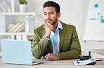 Young focused mixed race businessman working alone on a laptop in an office at work. One hispanic male boss thinking while reading an email on a laptop. Man sitting at a desk looking at a laptop