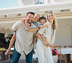 Portrait of happy parents giving their little children piggyback rides outside in a garden. Smiling caucasian couple bonding with their adorable son and daughter in the backyard. Playful kids enjoying