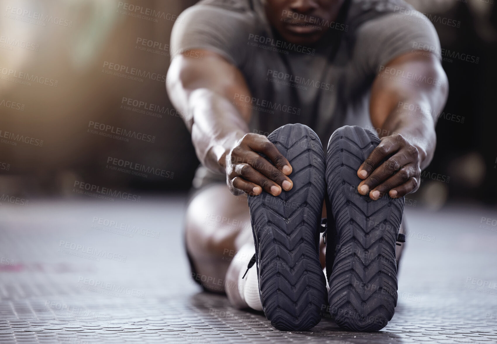 Buy stock photo Stretching, feet and exercise with a man at gym for fitness, muscle and training workout. Athlete person with hands on shoes for warm up, goals and performance motivation on floor at a wellness club 