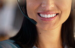 Closeup of one happy caucasian call centre telemarketing agent with big smile talking on headset while working in office. Face of confident friendly businesswoman operating helpdesk for customer service and sales support