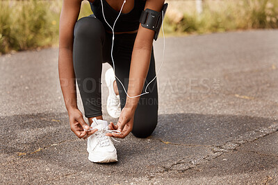 Buy stock photo Hands, shoes and fitness woman in a road for training, wellness and morning cardio in nature with music. Feet, action and girl runner with shoelace check in a street for exercise, run or workout