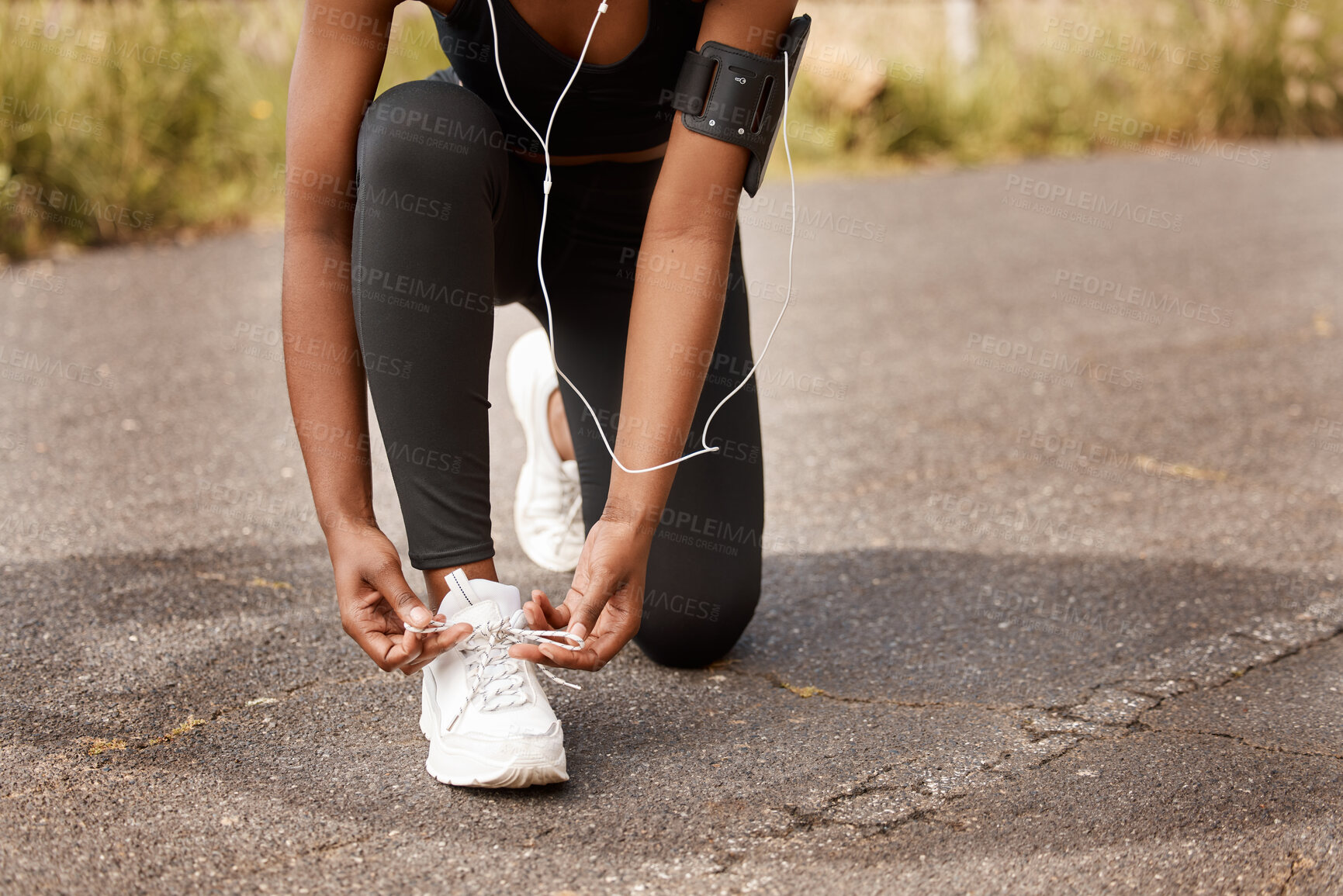 Buy stock photo Hands, shoes and fitness woman in a road for training, wellness and morning cardio in nature with music. Feet, action and girl runner with shoelace check in a street for exercise, run or workout