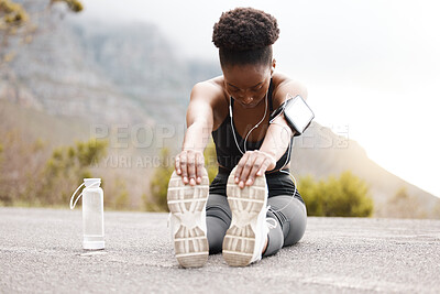 Buy stock photo Feet, stretching and black woman in road for running, workout or training in nature with music or water. Exercise, wellness or girl runner streaming podcast with body warm up for sports performance