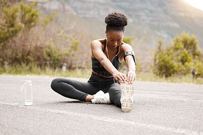 Buy stock photo Fitness, black woman or stretching feet in road for running, workout or training at sunset with music or water. Exercise, wellness or runner streaming podcast with body warm up for sports performance