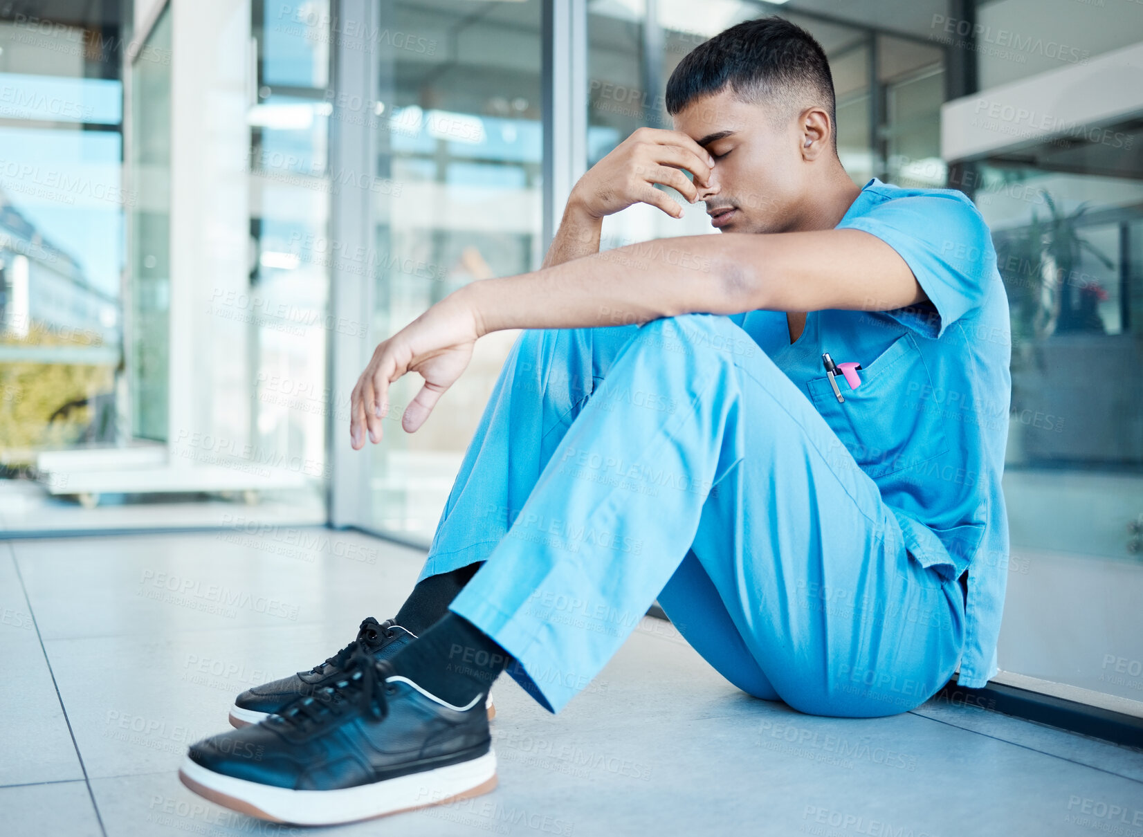 Buy stock photo Surgeon, man and sad on floor at hospital for decision, mistake and burnout with stress for healthcare. Person, doctor or nurse in lobby for anxiety, tired or headache on break at wellness clinic