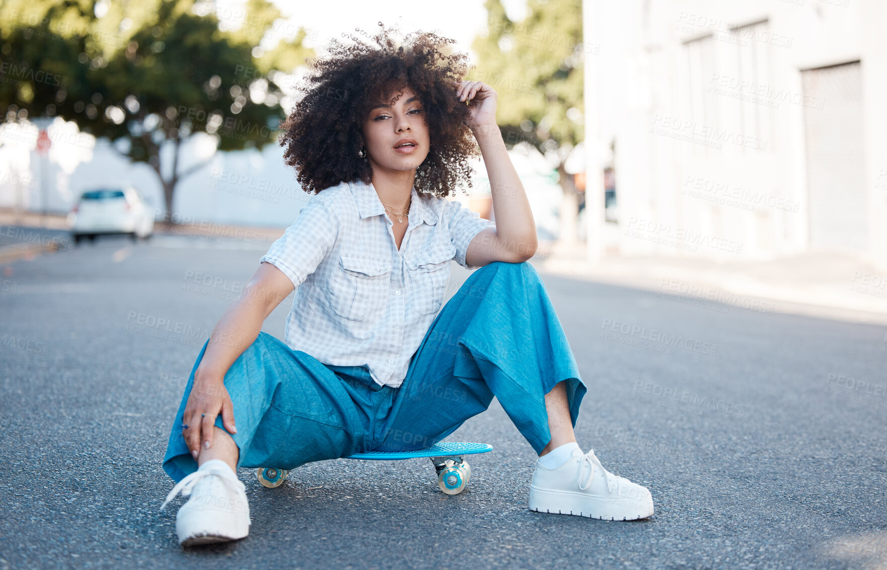 Buy stock photo Woman, portrait and sitting on skateboard in street with fashion, confidence and edgy style in city. Girl, skater or gen z person with streetwear, sneakers and curly hair on road with trendy clothes