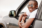 One African American man with his arm hanging out of the window, happy and looking back while taking a roadtrip. Black man enjoying the weekend and taking a trip in a vehicle while wearing sunglasses