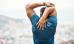 One active mixed race man from the back stretching arms and triceps by pulling elbow with hands towards spine behind head while exercising outdoors. Muscular male athlete doing warmup to prepare body and muscles for training workout or run