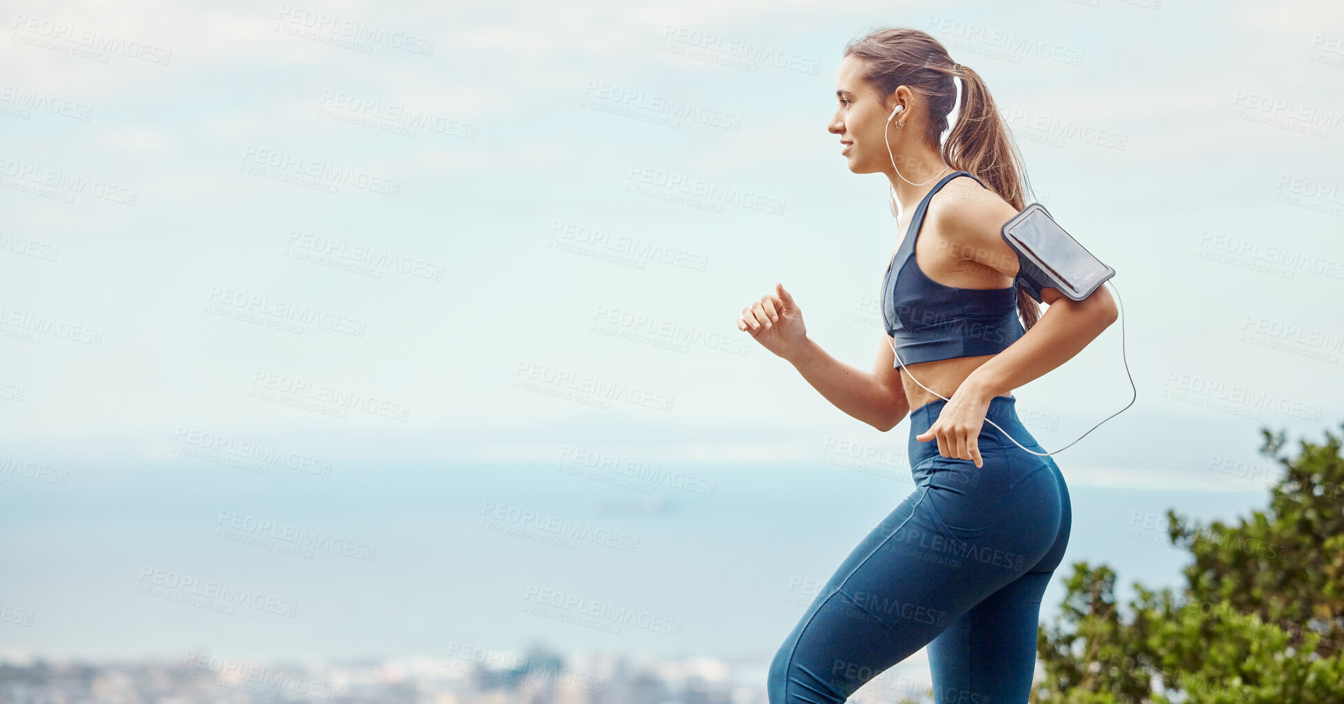 Buy stock photo Running, outdoor and woman with music, listening and armband for earphones, online and cellphone. Fitness, practice and jog for competition, cardio and workout for girl in sportswear and healthy