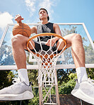 Sports, basketball and man sitting on basketball hoop and preparing for training, match or competition outdoors on basketball court. Portrait, basketball player and male on rim ready for exercise.