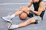 Basketball, man and knee in sports injury on the court holding painful, sore or tender area in the outdoors. Basketball player suffering from leg pain, joint or inflammation in sport match or game