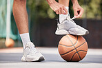 Tie shoes, sports and hands on a basketball court getting ready for training, cardio workout and fitness exercise. Footwear, sneakers and healthy athlete in preparation for a practice game or match