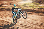 Motorcycle, dirt track stunt and air jump in desert, sand trail and freedom. Driver, cycling and offroad freedom, sports competition and motorbike performance on adventure course for fast action show