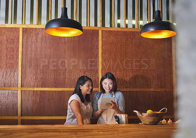 Buy stock photo Restaurant, tablet and asian women at counter together checking sales, booking or menu for small business. Social media, content marketing and startup cafe owner with waitress scroll on digital app.