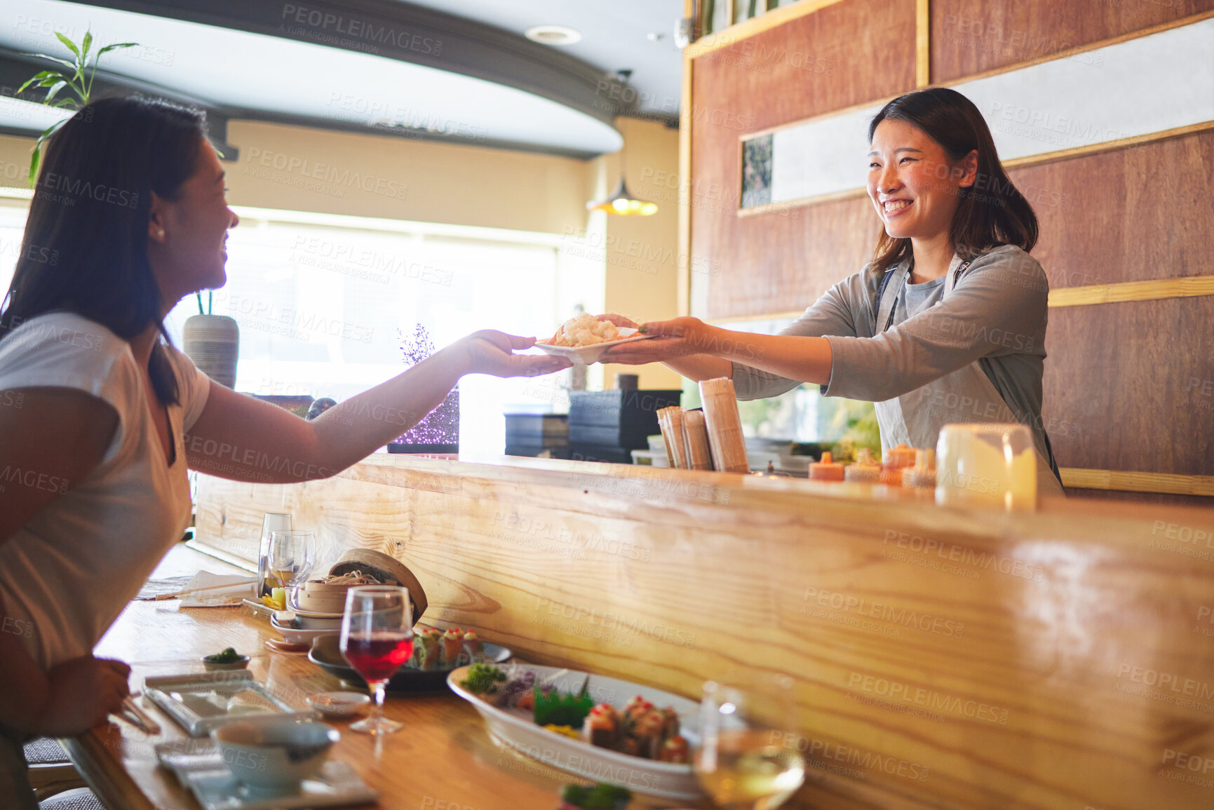 Buy stock photo Sushi, happiness and restaurant people, customer and Asian waitress giving food plate, order or product. Japanese cashier, server or startup small business owner with meal for happy client