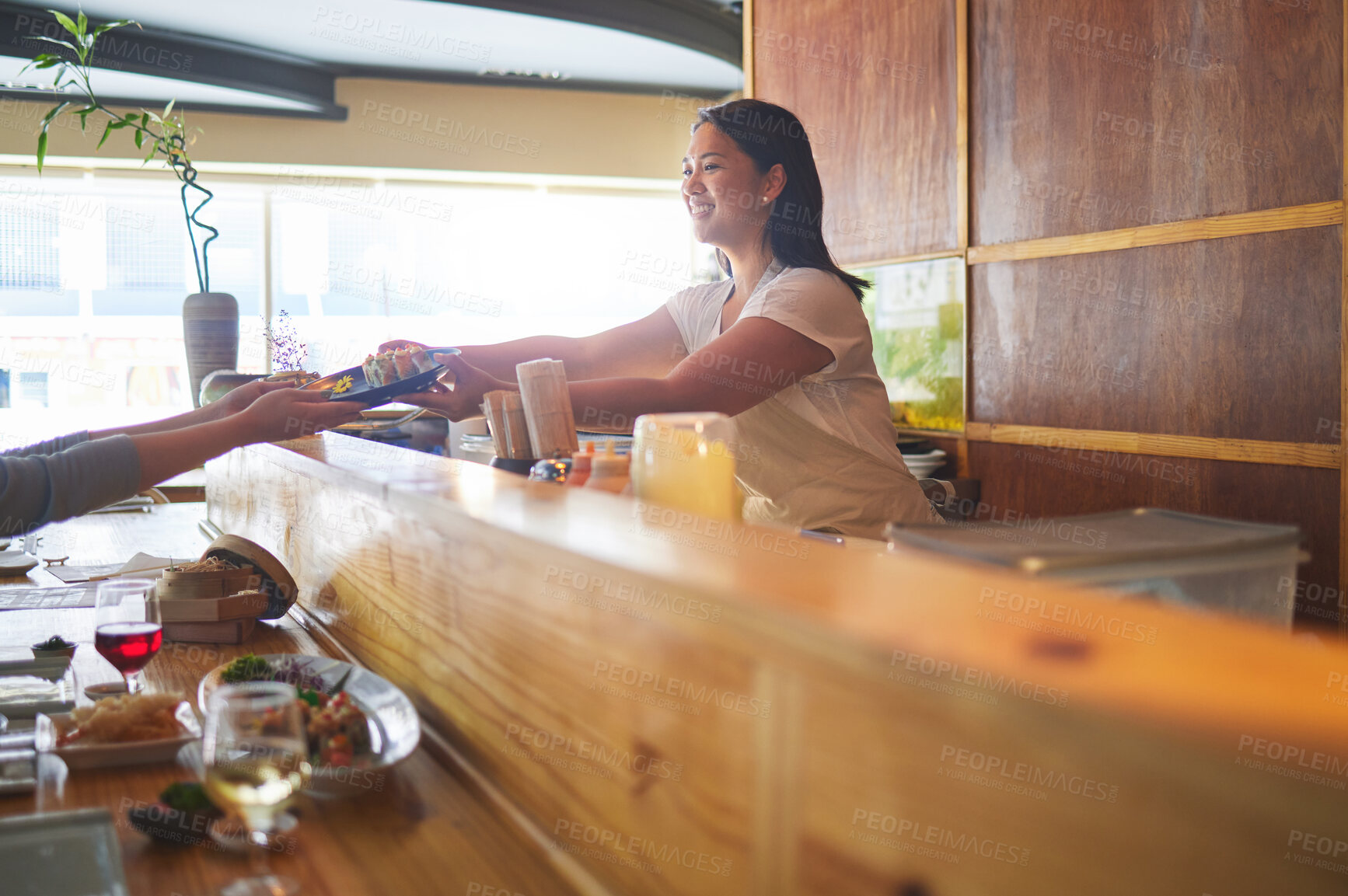 Buy stock photo Sushi serving, restaurant chef and woman with smile from food and Asian meal in a kitchen. Happy, female waiter working with lunch order with cooking and hospitality job in Japanese bar with service