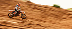 Motorcycle, freedom and motion blur with a sports man on space in the desert for dirt biking. Bike, fitness and power with a person driving fast on an off road course for challenge or performance