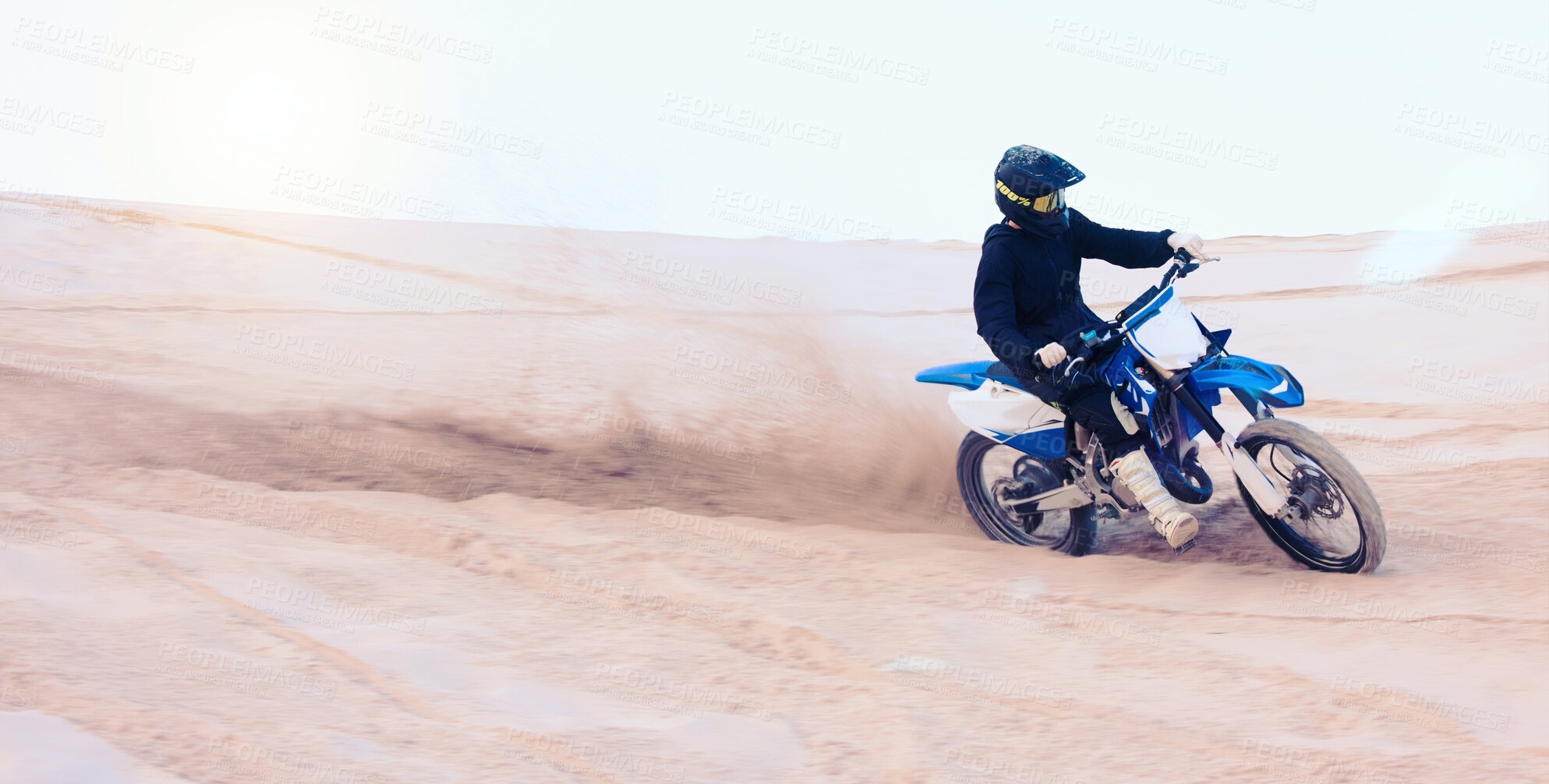 Buy stock photo Dirt, motorbike and athlete driving with speed in sports, adventure and sand in desert or man riding outdoor with sky or nature. Extreme sport, bike or motorcycle drive with helmet, gear or freedom