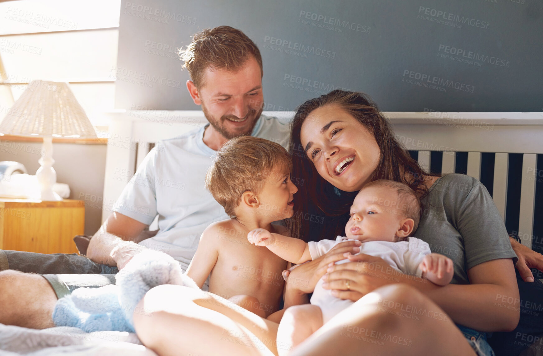 Buy stock photo Family, parents and children in bed of home, relax and weekend in bedroom. Cuddle, support and mother person with father for love and childhood development, kid and smile for care and happiness