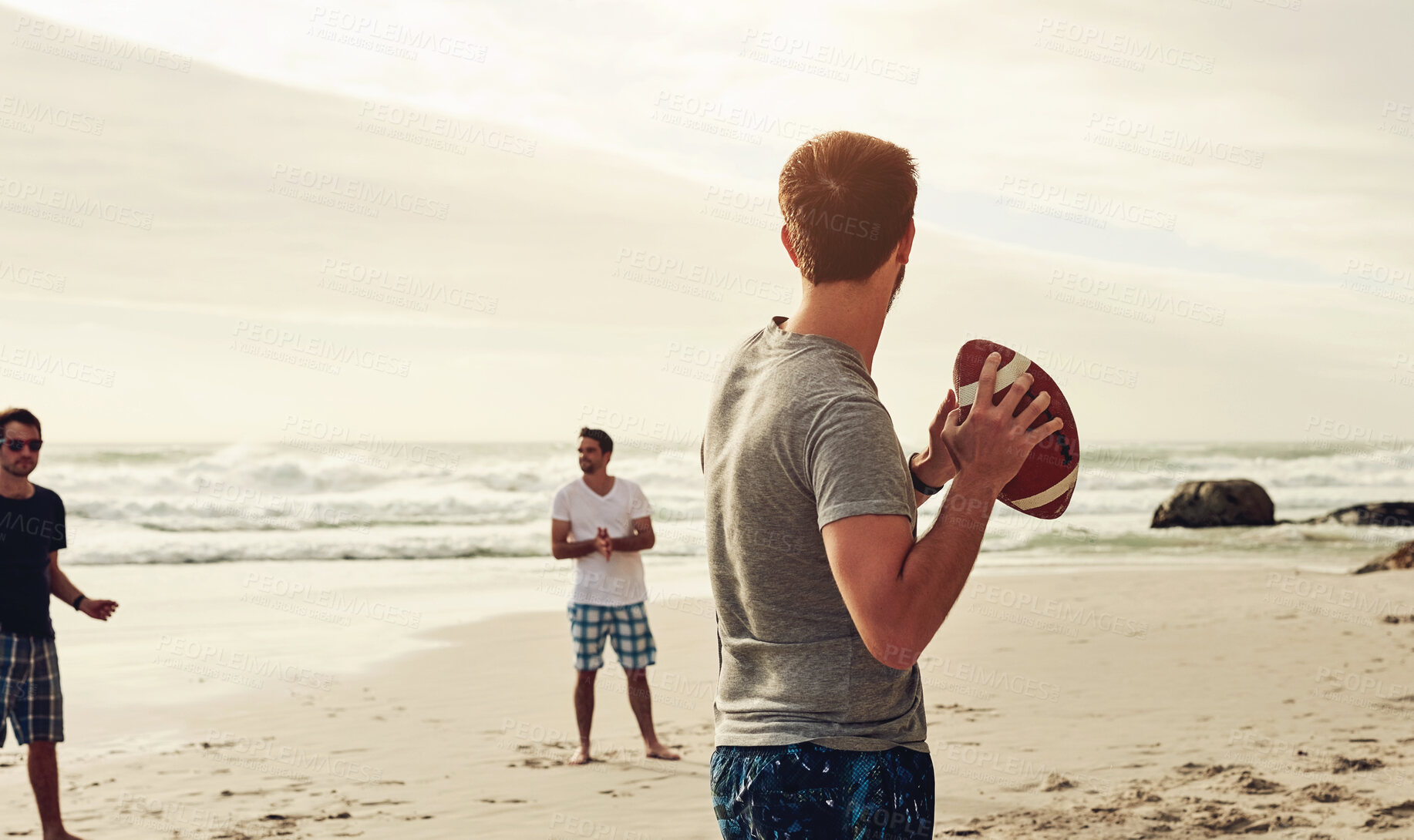 Buy stock photo Vacation, friends and man with football at beach for outdoor activity, game and adventure on weekend. Sports, people and playful with equipment on sand for seaside, fun and holiday in California
