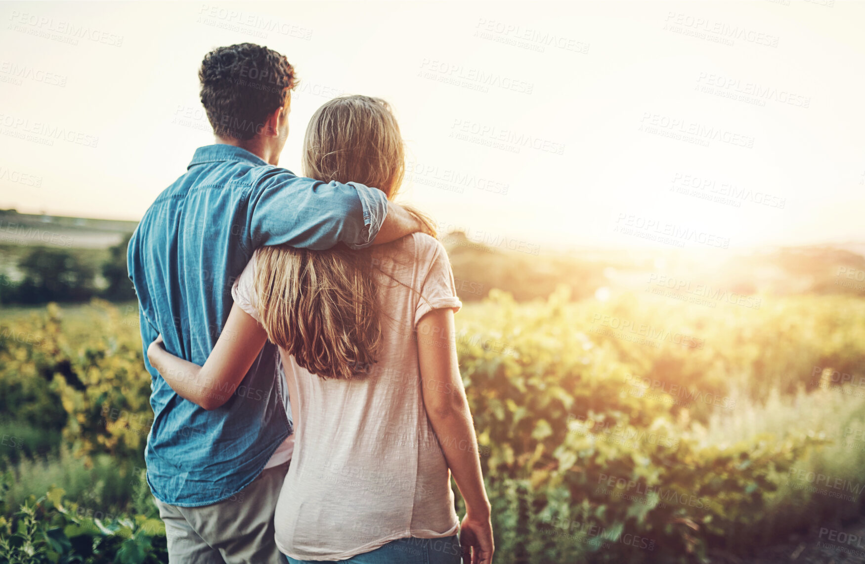 Buy stock photo Back, hug and couple in field, outdoor and bonding in nature, love and date for anniversary in park. Morning, partner and person with embrace, sunrise and view in countryside, farm or relax in Texas