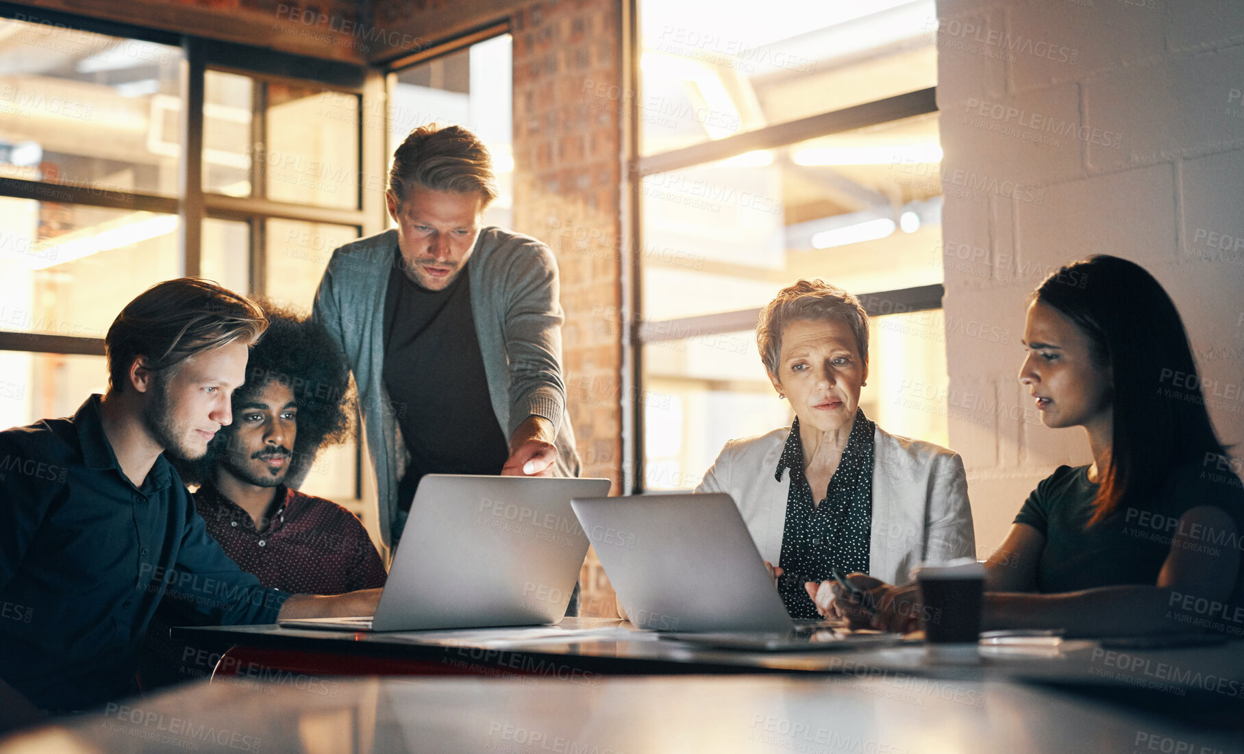 Buy stock photo Business people, meeting and journalists with laptop in office for newspaper planning at night. Press, teamwork and writers with tech for research, article feedback and collaboration for news blog